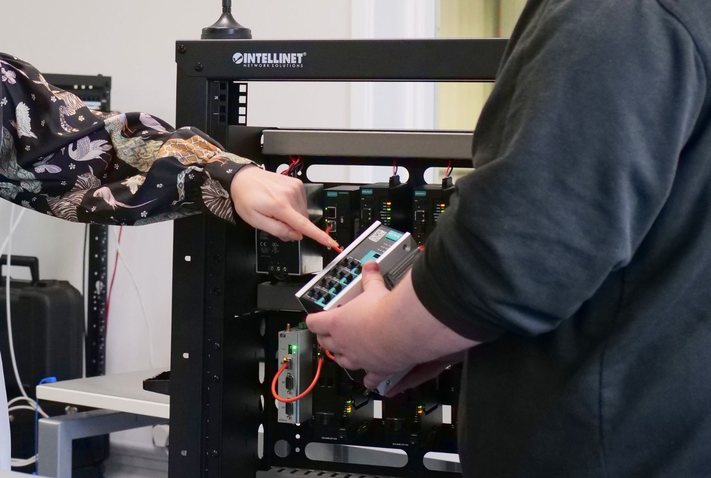 Two people discussing Moxa networking equipment.