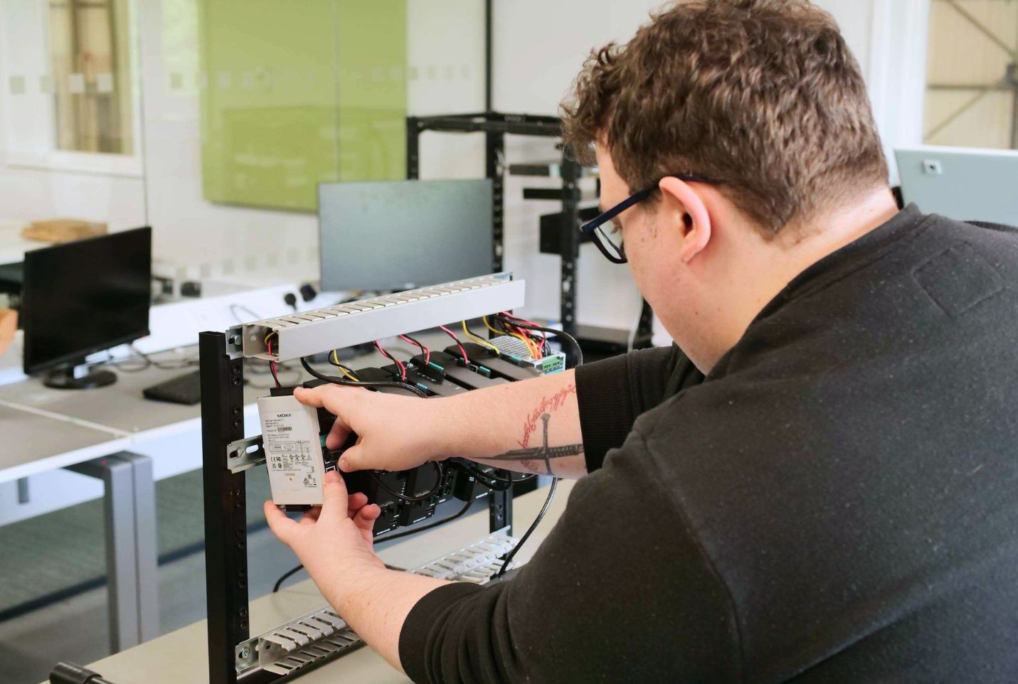 Engineer fitting equipment to a rack.